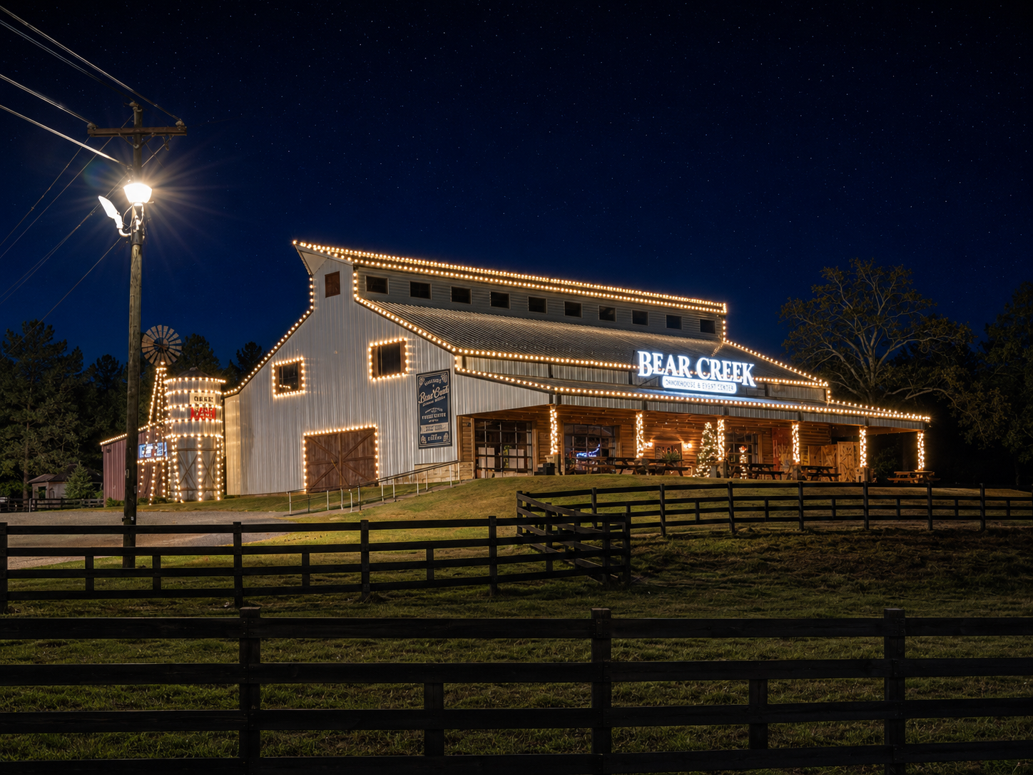Bear Creek Smokehouse event barn outlined in warm holiday lights at night in East Texas.